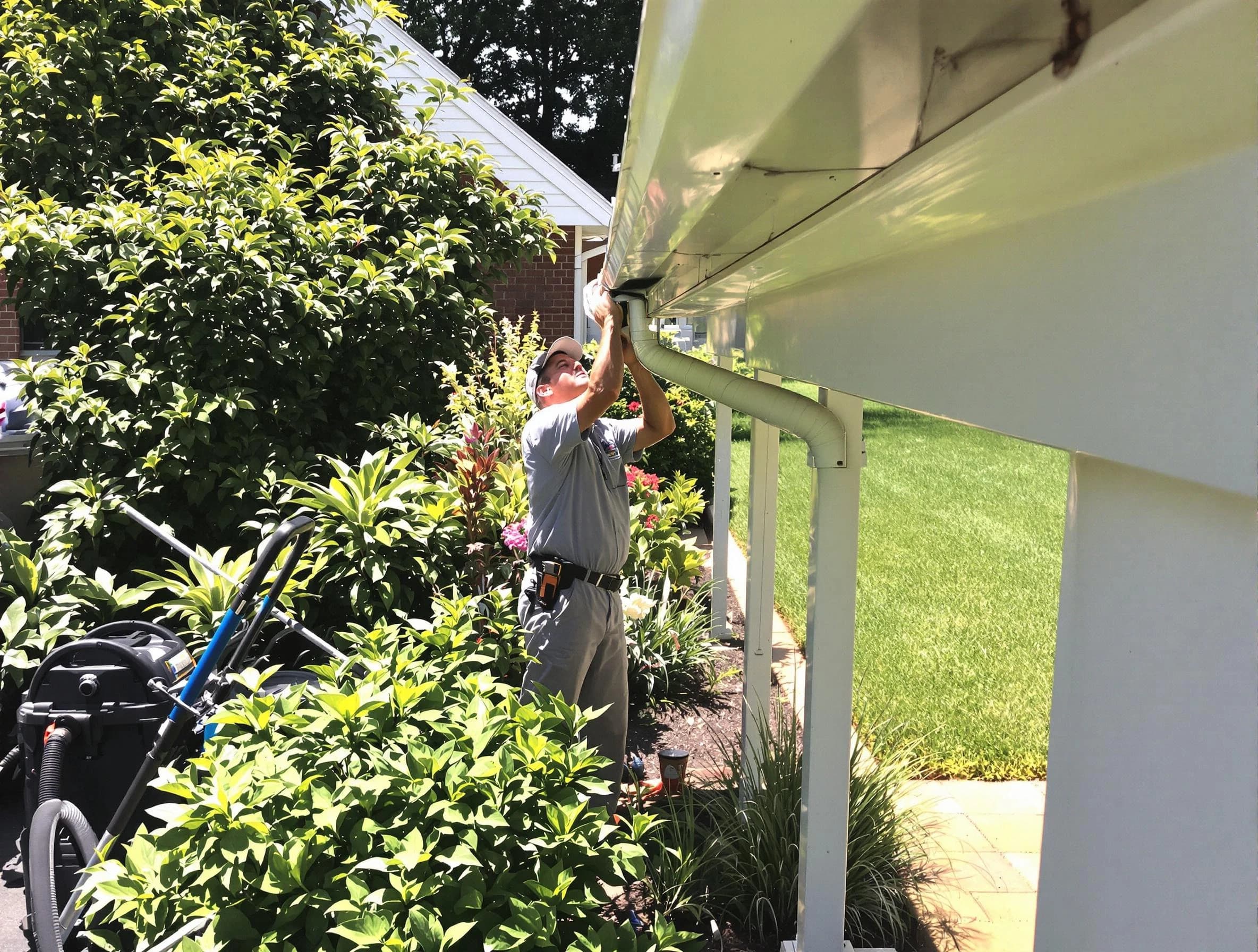 Technician flushing a blockage from a downspout in Hudson, OH